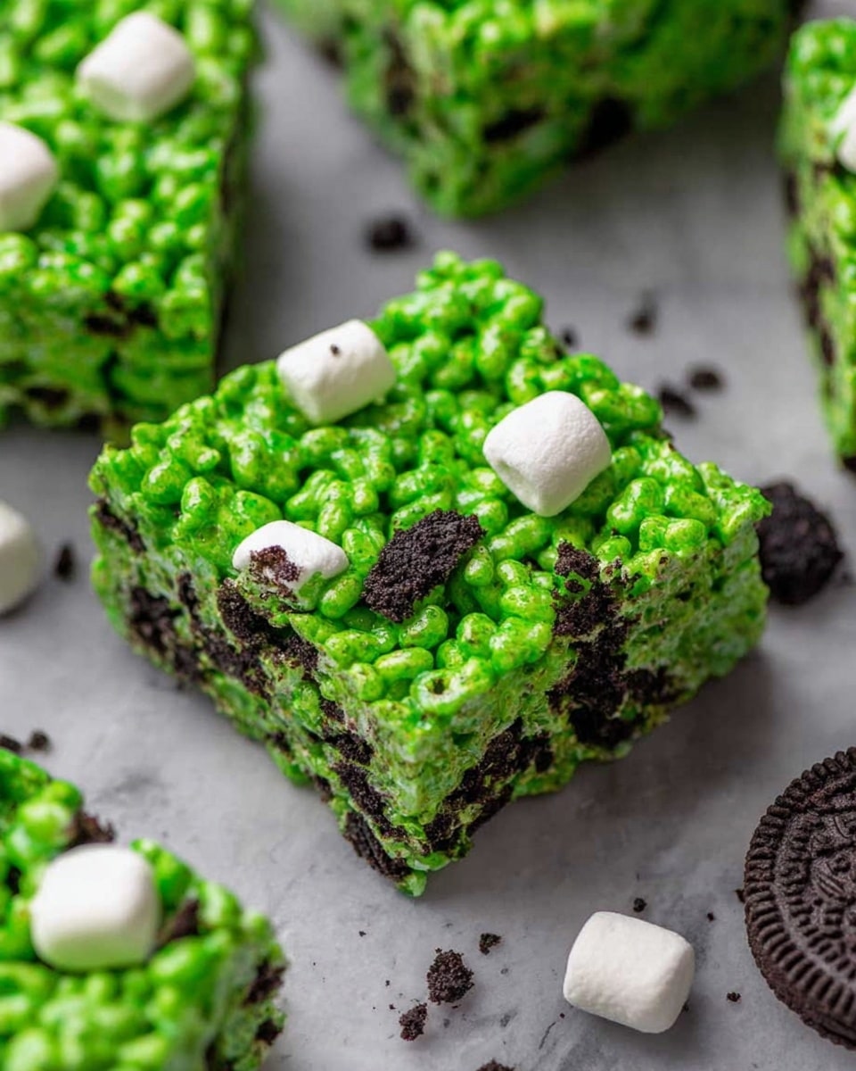 The image shows a close-up of bright green crispy rice treat bars that have one uniform layer made of puffed rice cereal in a shiny green coating with small dark cookie pieces mixed throughout. The squares are thick and slightly uneven in texture, with white mini marshmallows and cookie crumbs scattered around on a white marbled surface. The vibrant green color and the contrast with the dark cookie bits make the treats look fresh and crunchy. photo taken with an iphone --ar 4:5 --v 7
