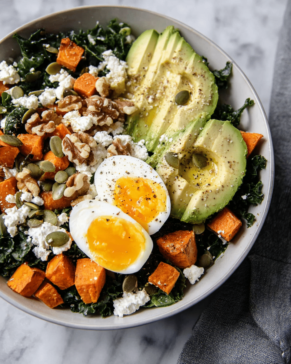 A bowl on a white marbled surface holds a layered salad starting with a dark green kale base. On top are bright orange roasted sweet potato cubes scattered around. Half an avocado with a light green creamy texture lies on one side, sprinkled with seeds and black pepper. Two soft-boiled eggs with white edges and golden yolks sit near the avocado. Crumbled white feta cheese is spread across the mix, along with brown walnuts and green seeds. A silver fork is placed beside the bowl, and a halved avocado with a brown seed rests on the marbled surface nearby. Photo taken with an iphone --ar 4:5 --v 7