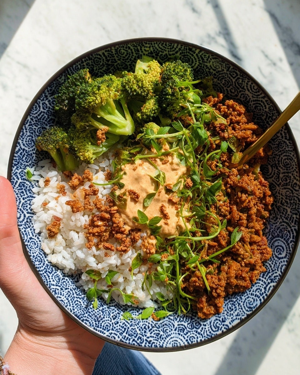 A round bowl with a blue geometric pattern holds a dish divided into three main sections: bright green broccoli pieces on the upper left side, a heap of white rice on the lower left side with small brown crispy bits sprinkled on top, and a rich brown textured cooked mixture on the right side. In the center, there is a dollop of creamy, light tan sauce with a slightly grainy look, garnished with fresh green sliced herbs scattered around the bowl. A gold spoon rests over the brown mixture near the right edge. A woman's hand holds the bowl from the bottom left corner against a white marbled surface. Photo taken with an iphone --ar 4:5 --v 7
