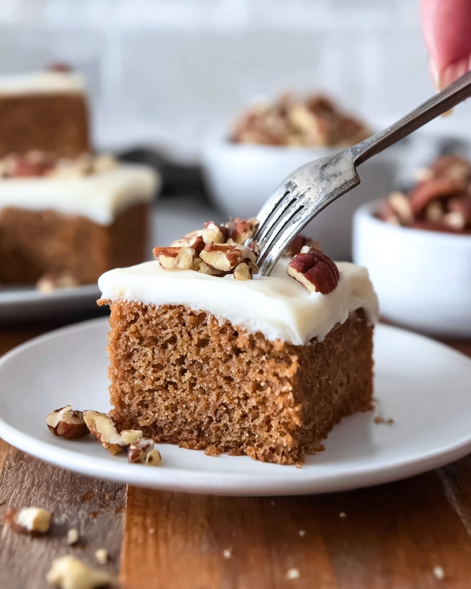 A close-up image shows a square piece of moist brown cake with a rough, soft texture and visible air holes, cut into two smaller sections but still touching. On top, there is a thick, smooth layer of creamy white frosting, neatly spread and topped with small, chopped brown pecans scattered on one side. A silver fork slices into the frosting and cake from above, held by a woman's hand. The cake sits on a simple white plate, placed on a wooden surface with a white marbled texture background slightly blurred behind, showing soft shapes of two white bowls filled with pecans and brown sugar. Photo taken with an iphone --ar 4:5 --v 7