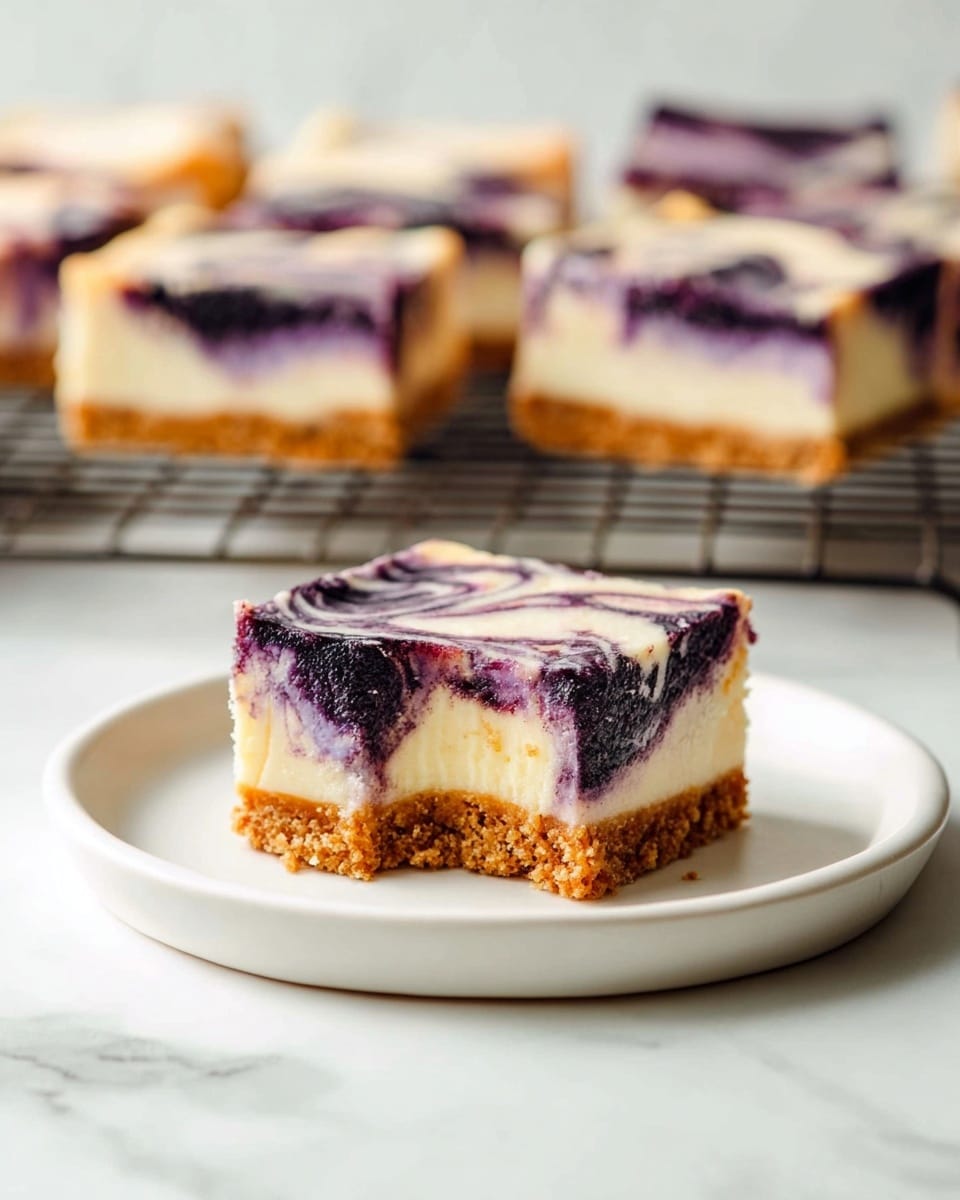 The image shows a single square slice of a marbled cheesecake bar on a white plate. This slice has three visible layers: a bottom crust layer that is golden brown and crumbly, a thick middle cream cheese layer that is pale and smooth, and a top layer with dark purple and white swirls creating a marble pattern. The slice has a bite taken out of the front edge, revealing the cream cheese and purple swirled layers inside. In the background, on a cooling rack, there are more similar cheesecake bars with the same marbled top and layered look on a white marbled surface. Photo taken with an iphone --ar 4:5 --v 7