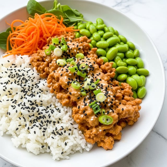 The dish is presented on a white plate with a background of white marbled texture. It has four main layers arranged side by side: at the bottom left, a layer of white rice sprinkled with black sesame seeds; next to the rice, a layer of cooked ground meat covered with creamy orange sauce and topped with chopped green onions and more black sesame seeds; behind the meat and rice, a layer of bright green edamame; and on the top left corner, there is a portion of shredded orange carrots with some green leafy garnish. Photo taken with an iphone --ar 4:5 --v 7