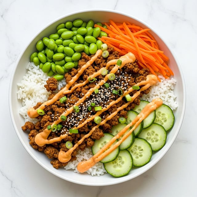 This dish is served in a large white bowl with a white marbled texture background. The base layer is fluffy white rice, covering about one-third of the bowl. Next to the rice are bright green edamame beans, smooth and shiny, along with thinly sliced cucumber rounds arranged neatly. There are shredded orange carrots adding a fresh crunch. The main feature is a crumbled cooked ground meat topping, golden brown and covered with a creamy orange spicy sauce that is drizzled generously. The dish is sprinkled with black sesame seeds and chopped green onions, adding a pop of green and a slight crunch on top. photo taken with an iphone --ar 4:5 --v 7