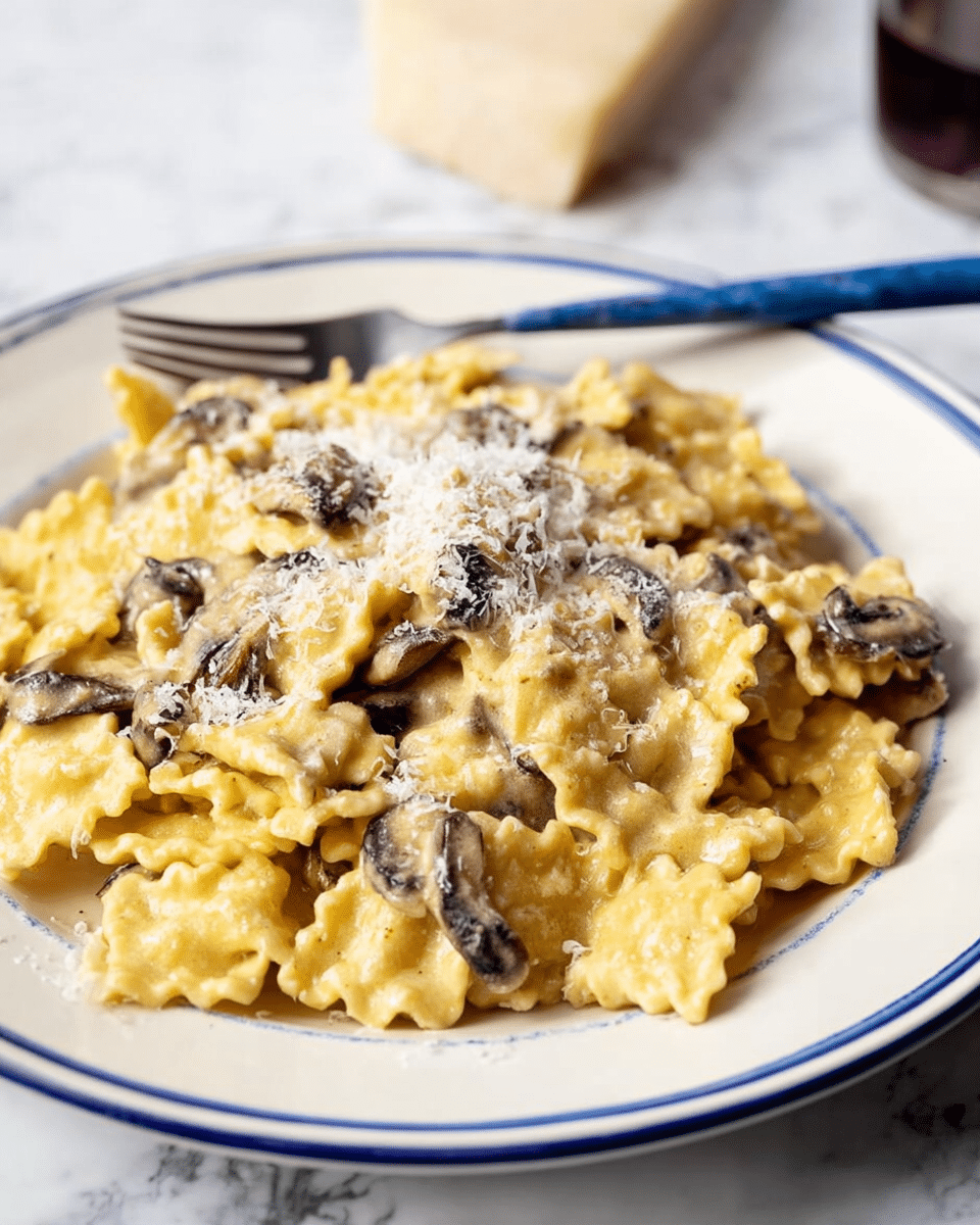The dish shows a mound of creamy yellow pasta with ruffled edges, coated in a smooth sauce, placed on a white plate with a blue rim. Scattered throughout the pasta are thin, dark brown mushroom slices that add contrast in color and texture. A fine sprinkling of white grated cheese is spread evenly on top, providing a delicate dusting over the creamy pasta. A blue fork lies behind the pile of pasta on the plate, and the scene is set on a white marbled surface. photo taken with an iphone --ar 4:5 --v 7