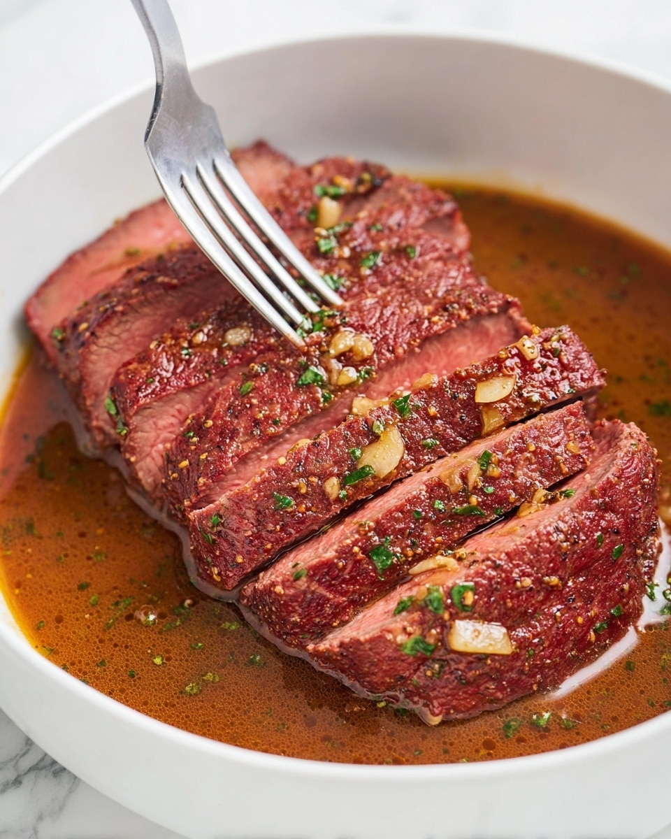 The image shows a white bowl filled with sliced cooked beef, arranged in a slightly overlapping row. The beef slices have a reddish-brown outer color and a pinkish center, showing they are medium-rare. The meat is covered with a sauce that is light brown and speckled with small bits of garlic and green herbs. A metal fork is inserted into one of the slices, lifting it slightly, with some sauce dripping onto the meat. The bowl sits on a white marbled surface. photo taken with an iphone --ar 4:5 --v 7