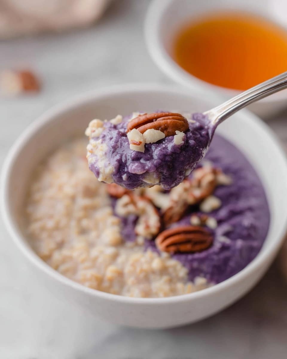 A white speckled bowl holds a breakfast dish with three visible layers: on the left, a creamy oatmeal layer with a light beige color and soft texture; next to it is a thick layer of dark purple blueberries mixed with a white cream or milk, creating a marbled effect; scattered on top are small chunks of brown pecans adding crunchy texture. The bowl is placed on a white marbled surface with small white bowls filled with pecans and a translucent amber liquid in the background, along with a few cinnamon sticks and a striped cloth in the foreground. photo taken with an iphone --ar 4:5 --v 7