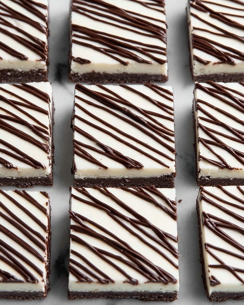 The image shows several square-shaped dessert bars arranged in a grid pattern over a white marbled surface. Each bar has two clear layers: a bottom dark brown base with a slightly rough texture, and a thick smooth white top layer. The white layer is decorated with an even drizzle of shiny dark chocolate lines running diagonally from corner to corner on each square piece. The bars are neatly cut with clean edges, and the contrast between the white and dark brown layers is very clear. Photo taken with an iphone --ar 4:5 --v 7