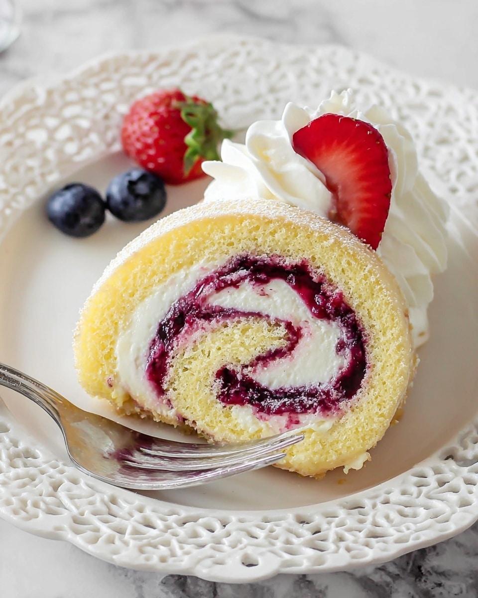 A single slice of a light yellow sponge cake roll filled with two visible layers of cream: a thick white creamy layer and a thin layer of dark purple berry jam swirled throughout the spiral. The roll sits on a white plate with a detailed lace-like rim, next to a dollop of white whipped cream topped with a bright red strawberry slice and two deep blue blueberries. A silver fork is placed on the left side of the plate. The whole scene is set on a white marbled texture. Photo taken with an iphone --ar 4:5 --v 7