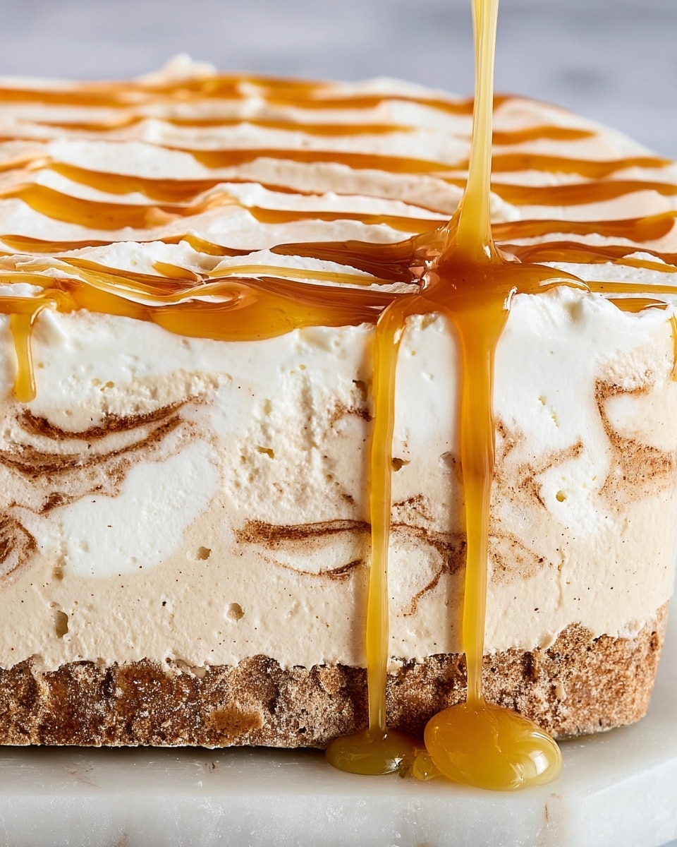 A close-up of a creamy dessert with three visible layers: the bottom layer is light beige with smooth, slightly cracked texture; the middle layer has swirls of light brown resembling cinnamon or spice mixed into the cream; the top layer is thick and white with a soft, fluffy texture. Over the top, a golden caramel sauce is being poured, creating shiny drips running down the sides, and some decorative lines of caramel are spread across the surface. The dessert rests on a white marbled surface. photo taken with an iphone --ar 4:5 --v 7