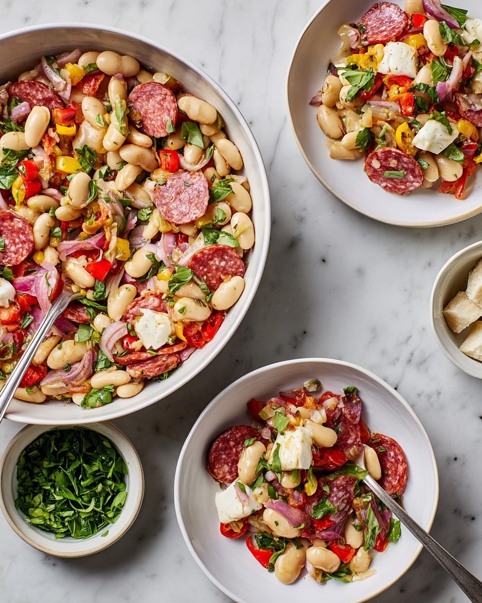 A close-up view of a white bowl filled with a mixed salad showing layers of white beans, small white mozzarella balls, thin slices of reddish pink salami, chopped red onions, small pieces of yellow and red peppers, and thin strips of fresh green basil leaves scattered throughout. The salad has a slightly glossy look from the light dressing, and a silver spoon is partially dipped into the bowl on the right side. The bowl sits on a white marbled surface. Photo taken with an iphone --ar 4:5 --v 7