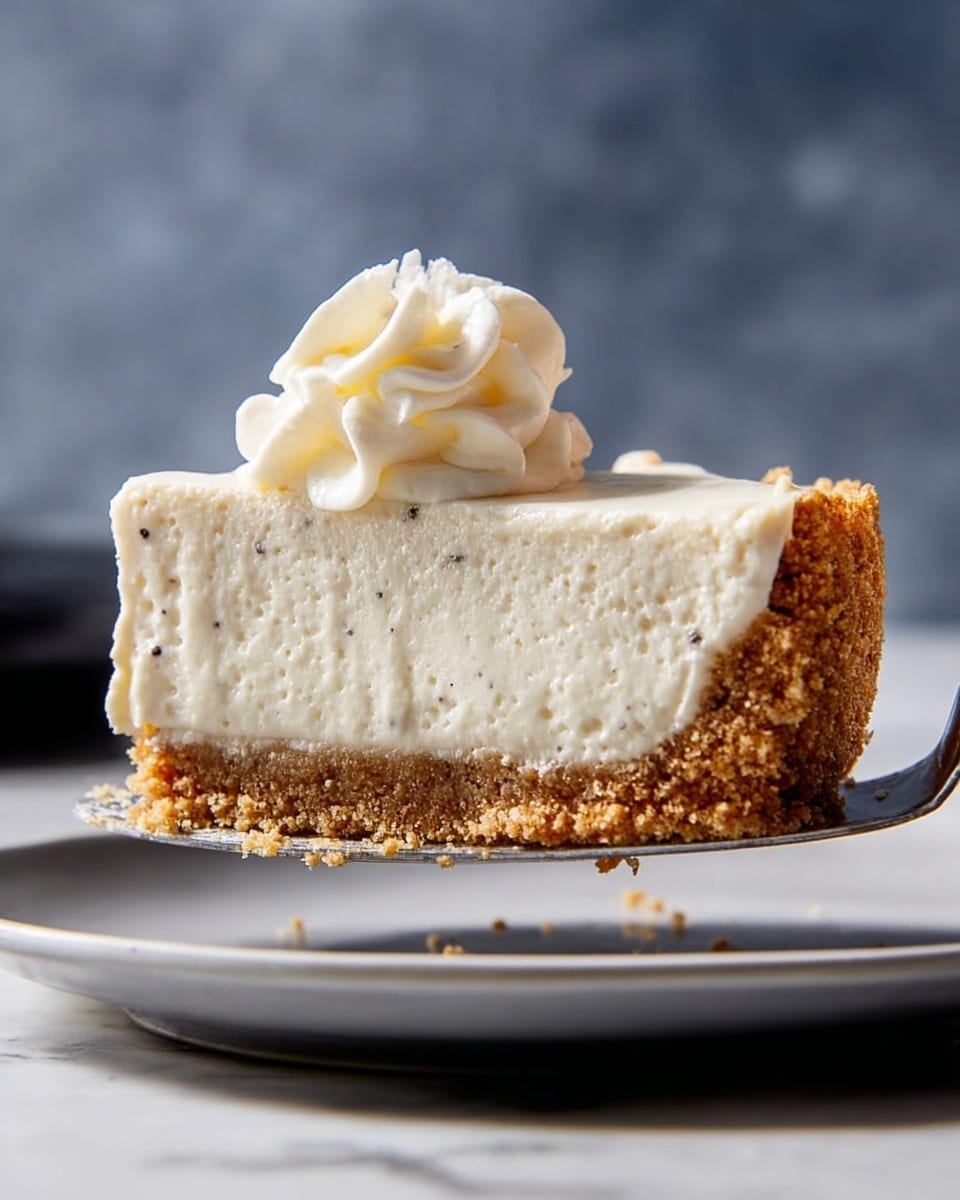 A thick slice of pie with two layers is shown being lifted by a silver pie server. The bottom layer is a crumbly, golden brown crust with a rough texture, and the top layer is a thick, creamy, off-white filling that is smooth with tiny dark specks. On top of the filling is a small swirl of whipped cream with a soft and fluffy texture. The pie is above a plain white plate on a white marbled surface with a blurred grey-blue background. photo taken with an iphone --ar 4:5 --v 7