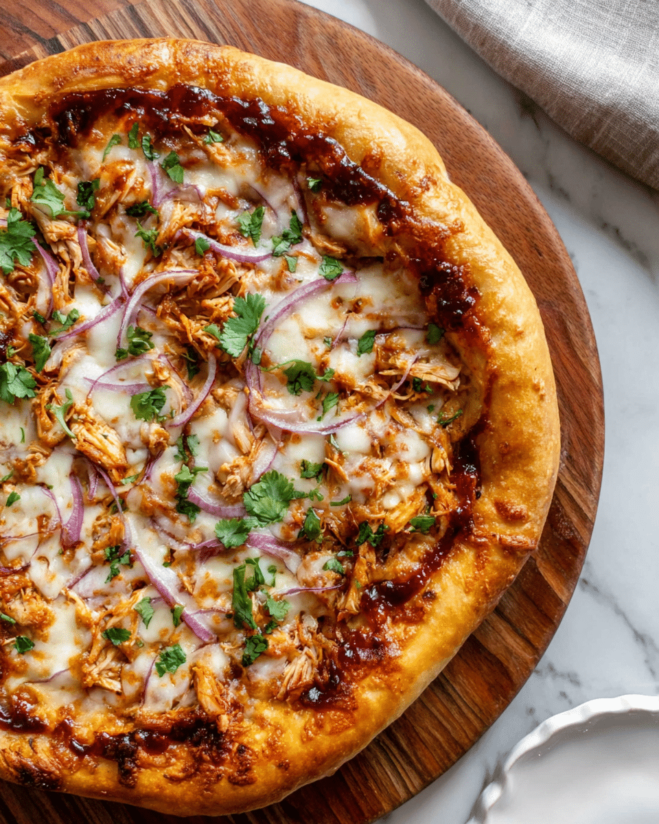A close-up view of a pizza with thick golden-brown crust on a round wooden board, topped with a layer of melted white cheese with parts that are lightly browned, a mix of barbecue sauce in dark reddish-brown patches under the cheese, thin slices of red onion scattered evenly, shredded chicken pieces, and small green cilantro leaves sprinkled on top. The pizza sits on a white marbled surface with a white fluted-edge plate partially visible at the bottom. photo taken with an iphone --ar 4:5 --v 7