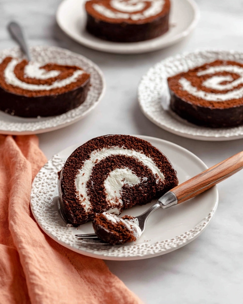 A close-up view of four slices of chocolate Swiss roll cake arranged on white plates of different patterns, each slice showing a spiral pattern with three layers: a dark chocolate outer layer, a middle layer of rich chocolate cake, and an inner swirl of white cream. The slice on the foreground white plate has a bite taken out with a fork holding the piece close to it, and the fork has a wooden handle. The cakes rest on a white marbled surface, and a peach-colored cloth is placed beside the plate with the fork. photo taken with an iphone --ar 4:5 --v 7