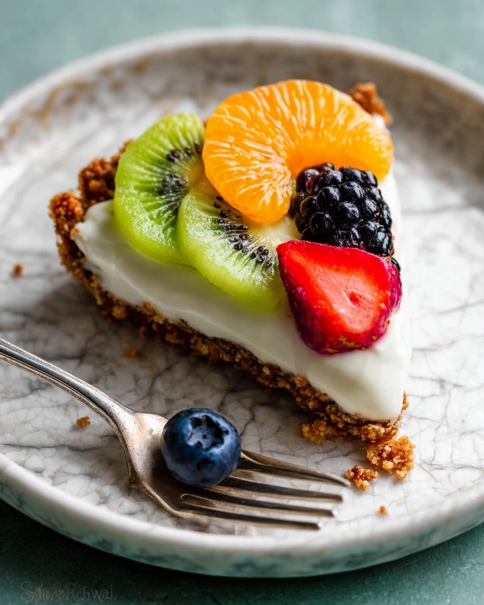 A slice of fruit tart sits on a white plate with a white marbled texture. The tart has a crumbly brown crust as the bottom layer, topped with a thick white creamy layer. On top, there are colorful fruit slices including two bright green kiwi slices, one orange mandarin slice in the center, two red strawberry halves, and a few dark blueberries and blackberries scattered around. A silver fork holds a small piece of the tart with a blueberry on it, placed beside the slice. Photo taken with an iphone --ar 4:5 --v 7