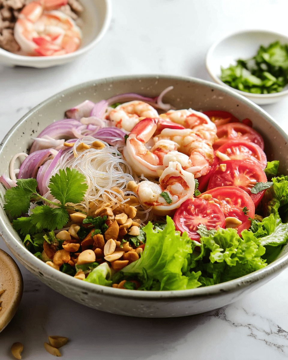 A bowl of clear glass noodles forms the center layer, topped with bright pink shrimp placed around the edges and center, with some tails showing. Underneath, there are slices of red tomato and slivers of purple onion mixed in with bits of ground meat at the bottom, giving a varied texture. Scattered on top are green cilantro leaves and crushed peanuts, adding small pops of color and crunch. Two wooden chopsticks with green and beige designs rest diagonally on the bowl. The bowl is white and sits on a white marbled surface with a few peanut pieces nearby. photo taken with an iphone --ar 4:5 --v 7