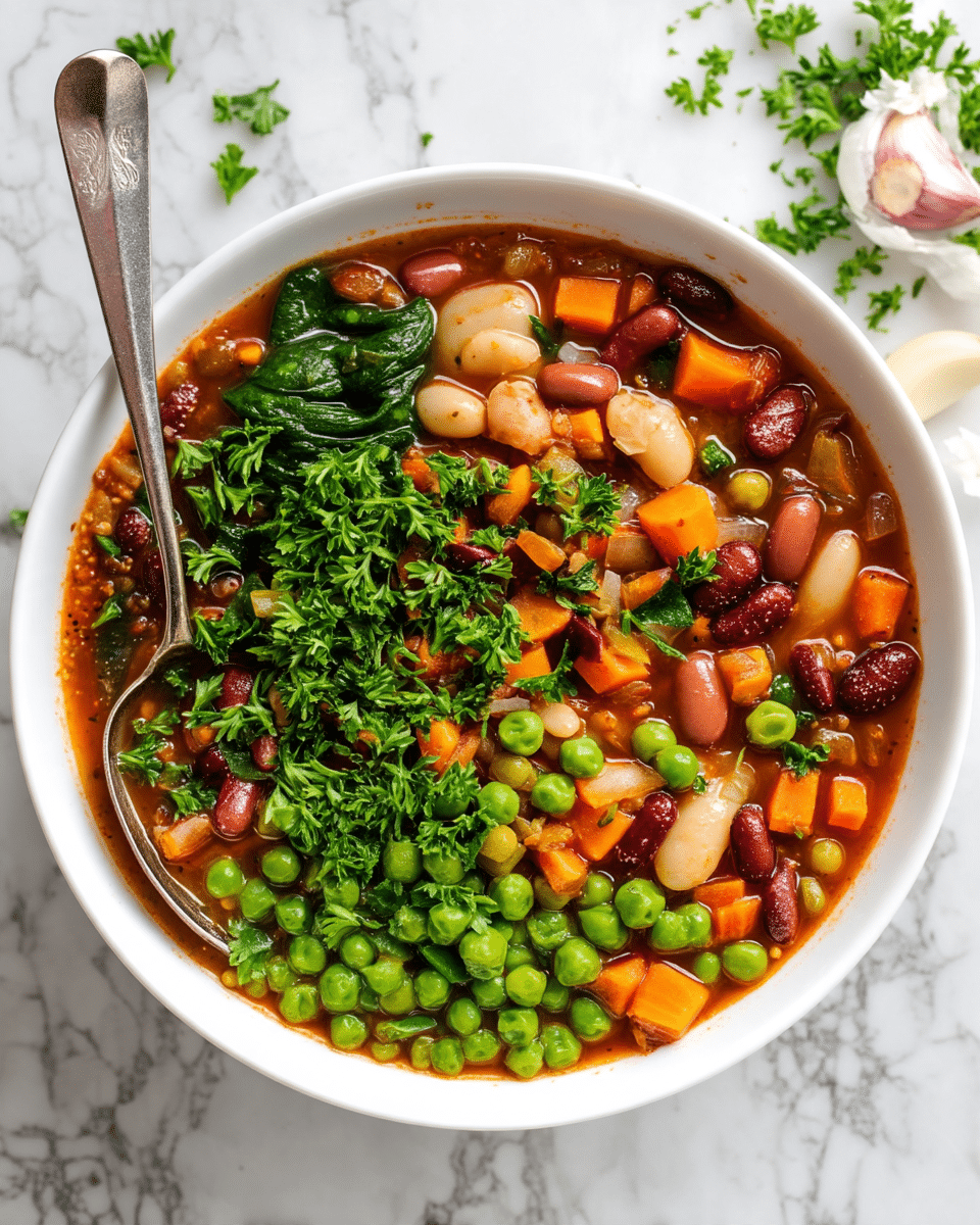 A white bowl filled with a thick vegetable and bean stew, showing about three layers of ingredients mixed in a reddish-brown broth. The bottom layer has small orange carrot cubes, tiny diced celery, and green peas scattered evenly. The middle layer consists of light beige and dark red kidney beans, larger white beans, and small bits of diced onions and lentils. The top layer has fresh green spinach leaves and chopped parsley sprinkled generously. A vintage silver spoon rests inside the bowl on the left side, partially submerged in the stew. The bowl sits on a white marbled surface with some garlic cloves in the top right corner. Photo taken with an iphone --ar 4:5 --v 7